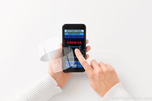 Image of hand holding phone with certificate of vaccination