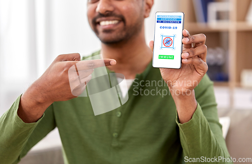 Image of man with certificate of vaccination on smartphone