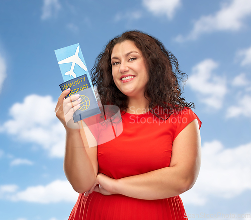 Image of happy woman with immunity passport and air ticket