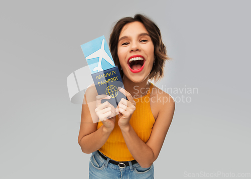 Image of happy woman with air ticket and immunity passport