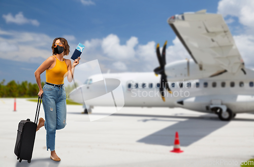 Image of woman in mask with bag and ticket over plain