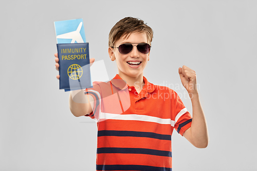 Image of happy boy with air ticket and immunity passport