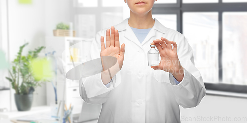 Image of doctor with syringe shows stop gesture at hospital