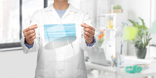 Image of female doctor showing medical mask at hospital