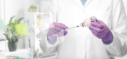 Image of close up of doctor with medicine and syringe