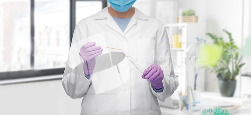 Image of female doctor with test tube and cotton swab