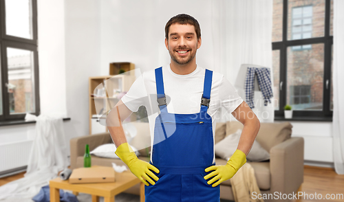 Image of happy male worker or cleaner in gloves at home