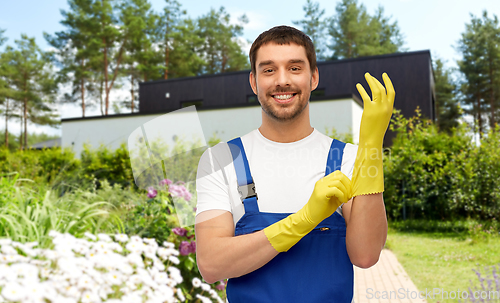 Image of male worker or cleaner in gloves at garden