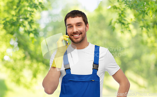 Image of happy male worker or cleaner calling on smartphone