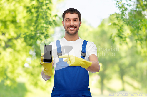 Image of happy male worker or cleaner showing smartphone