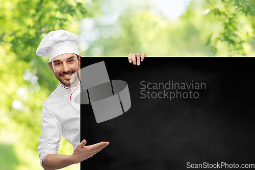 Image of happy smiling male chef with big black chalkboard