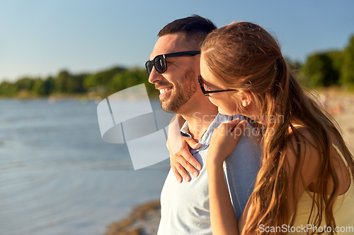 Image of happy couple hugging on summer beach