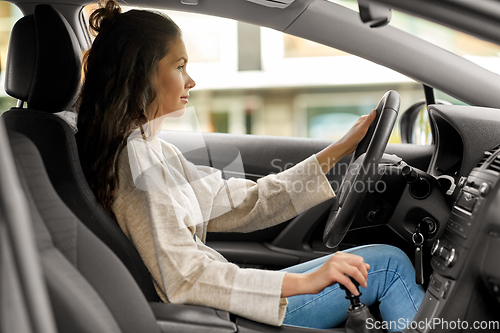 Image of woman or female driver driving car in city