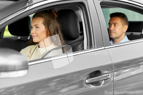 Image of female driver driving car with male passenger