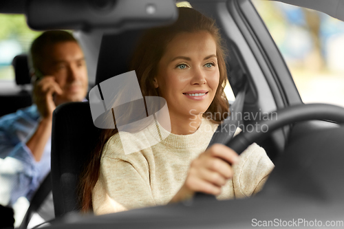 Image of female driver driving car with male passenger