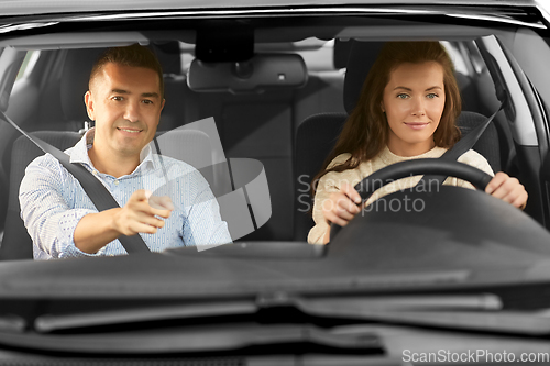 Image of car driving school instructor teaching woman