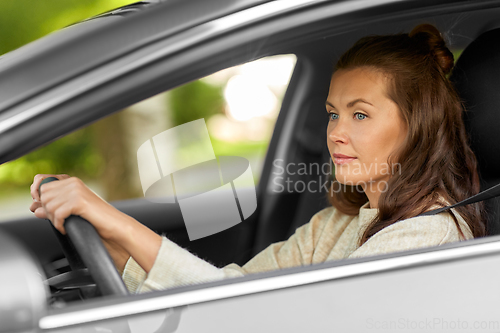 Image of woman or female driver driving car in city