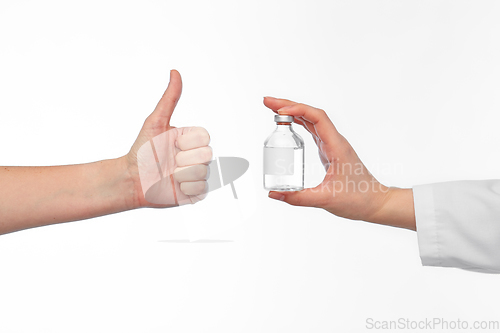 Image of hand with medicine and showing thumbs up