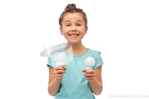 Image of smiling girl comparing different light bulbs