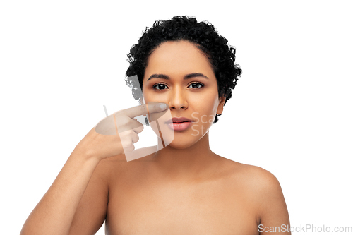 Image of young african american woman pointing to her nose