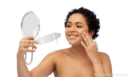 Image of smiling african american woman looking to mirror