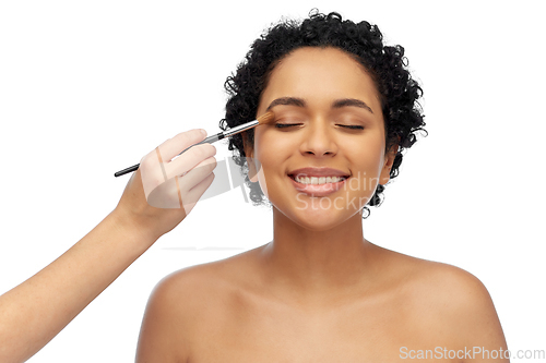 Image of happy woman and hand of make up artist with brush