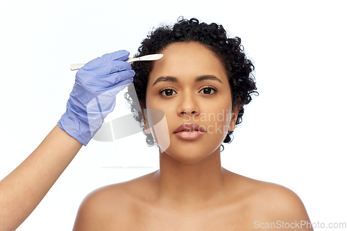 Image of african american woman and hand with scalpel knife