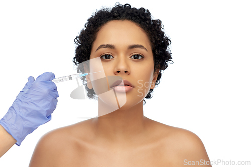 Image of face of african woman and hand with syringe