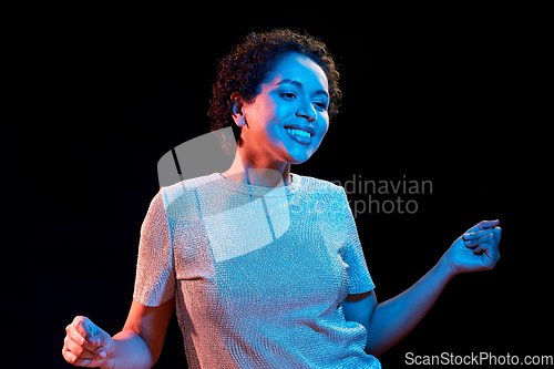 Image of african american woman dancing over neon lights