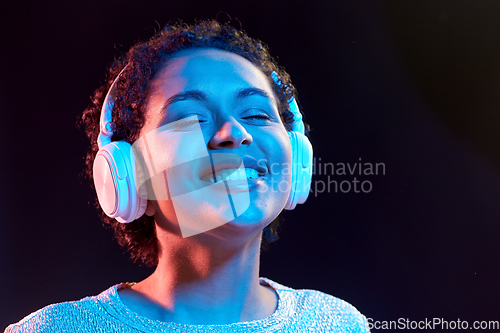 Image of woman in headphones listening to music and dancing