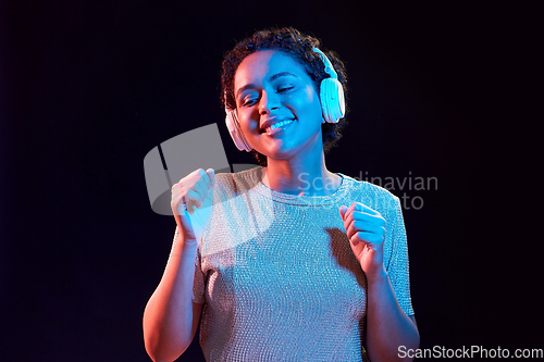 Image of woman in headphones listening to music and dancing