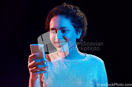 Image of african woman with smartphone in neon lights