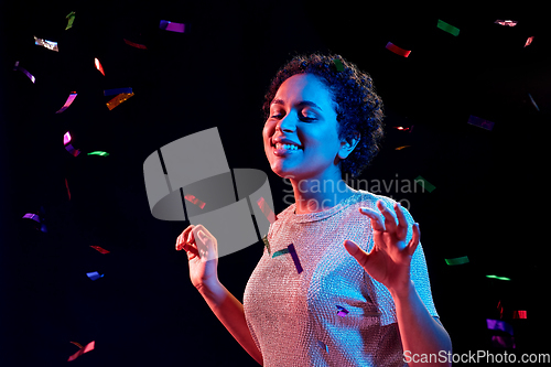 Image of african woman under confetti at nightclub party