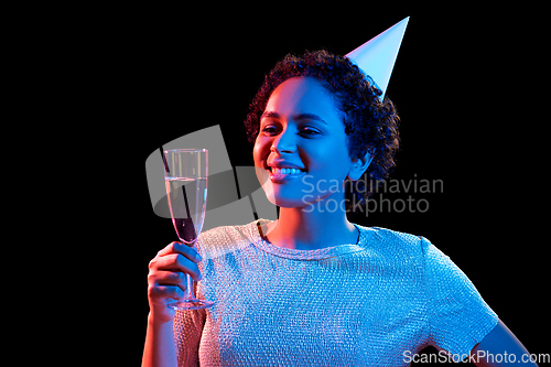 Image of african woman in party cap with glass of champagne