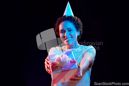 Image of african woman in party cap with gift box on black