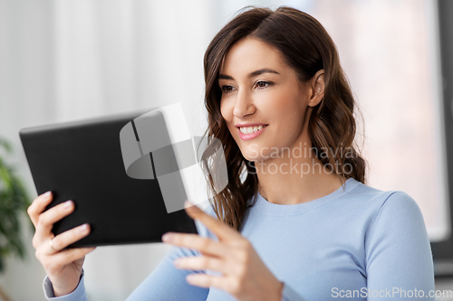 Image of happy smiling young woman with tablet pc at home