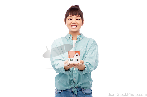 Image of smiling asian woman holding house model