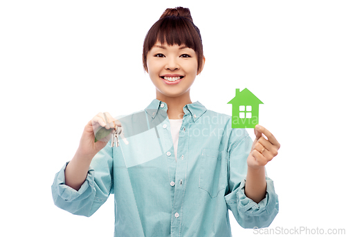 Image of smiling asian woman holding green house and keys