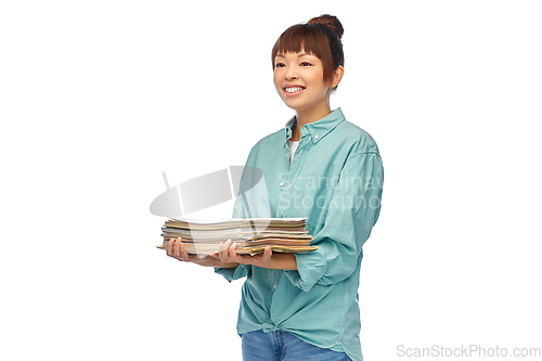 Image of smiling young asian woman sorting paper waste