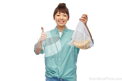 Image of happy woman with bananas in reusable net bag
