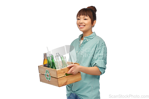 Image of smiling young asian woman sorting glass waste