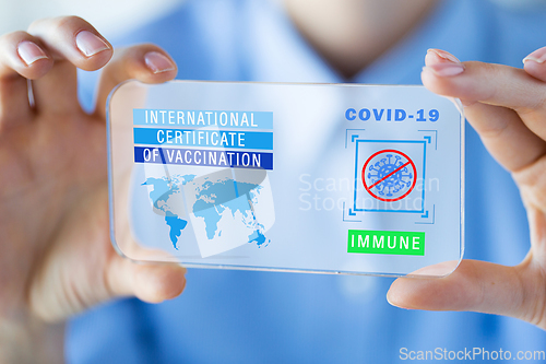 Image of hand with certificate of vaccination on smartphone