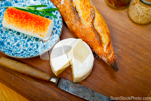 Image of French cheese and fresh  baguette on a wood cutter