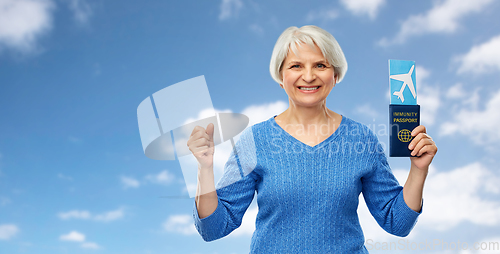 Image of senior woman with immunity passport and air ticket