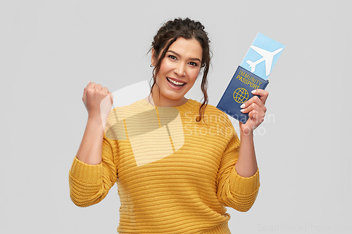 Image of happy woman with air ticket and immunity passport