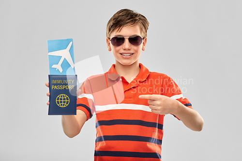 Image of happy boy with air ticket and immunity passport