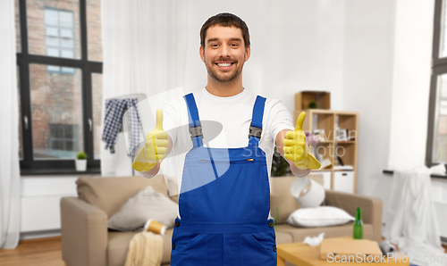 Image of happy male worker or cleaner in gloves at home