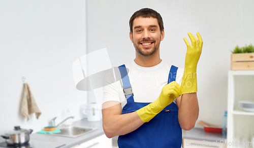 Image of happy male worker or cleaner in gloves at kitchen