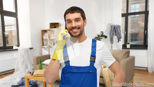 Image of male worker or cleaner calling on phone at home