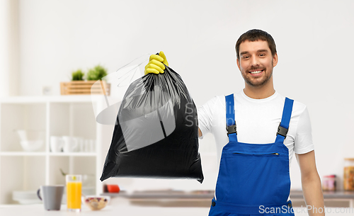 Image of male cleaner showing garbage bag at home kitchen